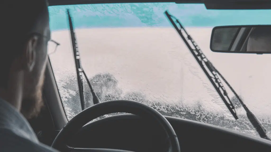 Voiture en cours de lavage dans un centre Wash, sous un ciel hivernal, avec mousse active et haute pression pour éliminer les saletés tenaces